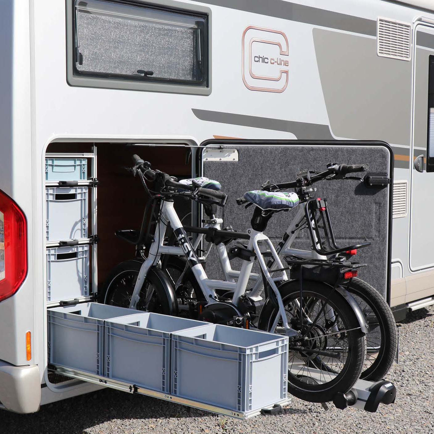 Stauraumlösung im Camper: dreistöckiges Regalsystem mit Schwerlastauszug für sechs Euroboxen. Zusätzlich ein Thule Velo Slide in der Heckgarage montiert.